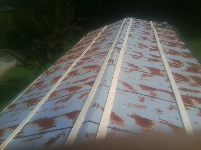 Rusted metal roof panels with new wood purlins before replacement — Storm Damage Roof Repair in Kyles Ford by Roofing Brothers