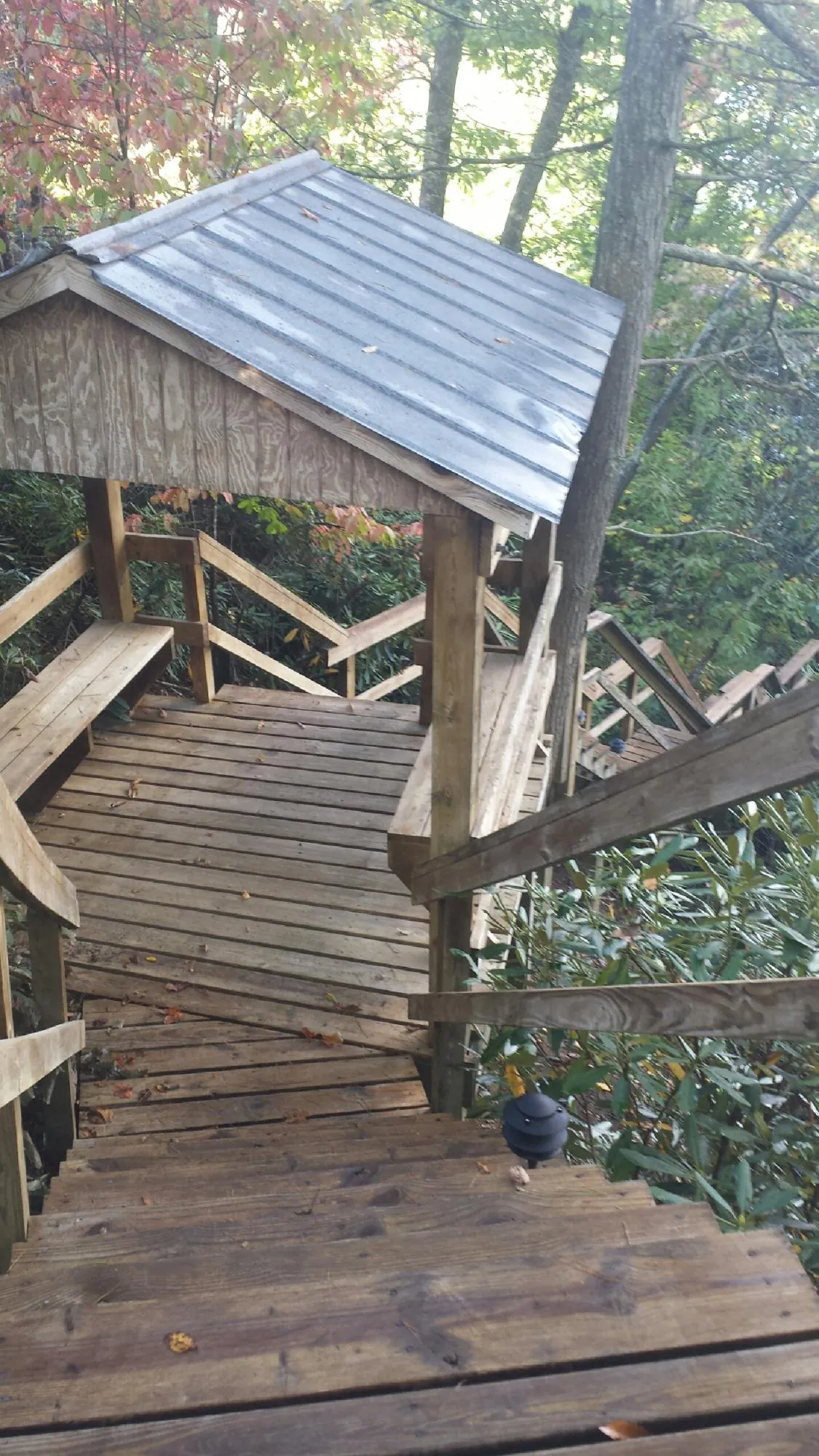Metal roofed shelter over wooden steps on a wooded walkway — Skylight Repair & Installation work by our crew in Kyles Ford