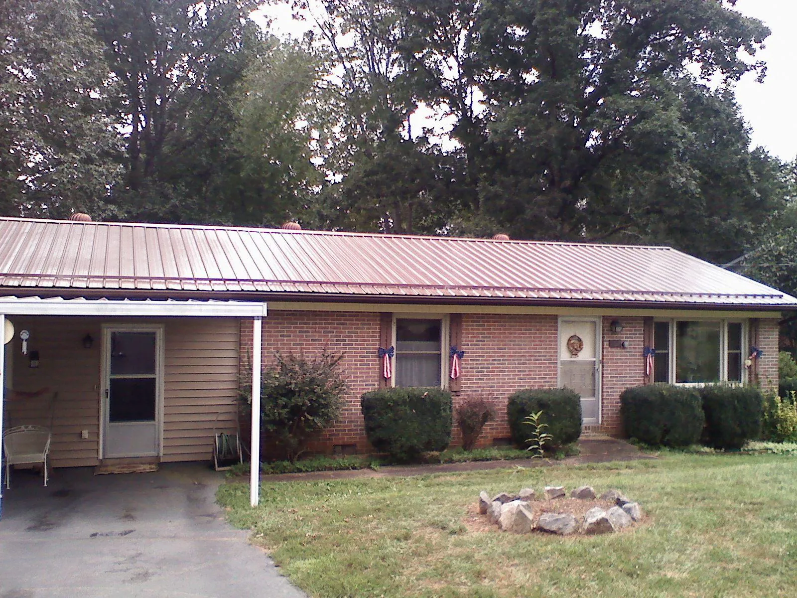 Bronze metal roof and carport on a brick ranch home — Roof Repair work by our crew in Kyles Ford